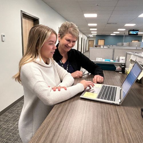 image de deux personnes regardant un ordinateur dans un poste d'infirmière d'un hôpital