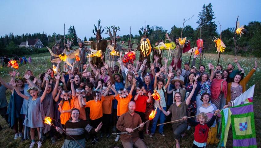 image of a group of people with hands held high in a field