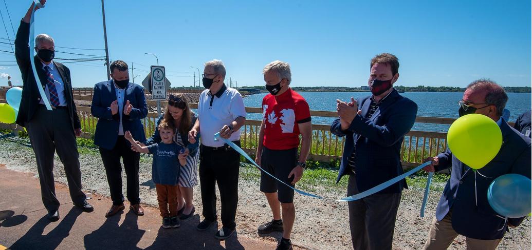 A number of people line up in front of the Hillsborough Bridge for the ribbon cutting to open the active transportation lane