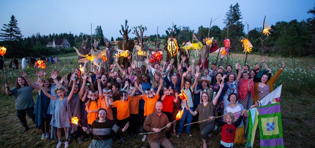 image of a group of people with hands held high in a field