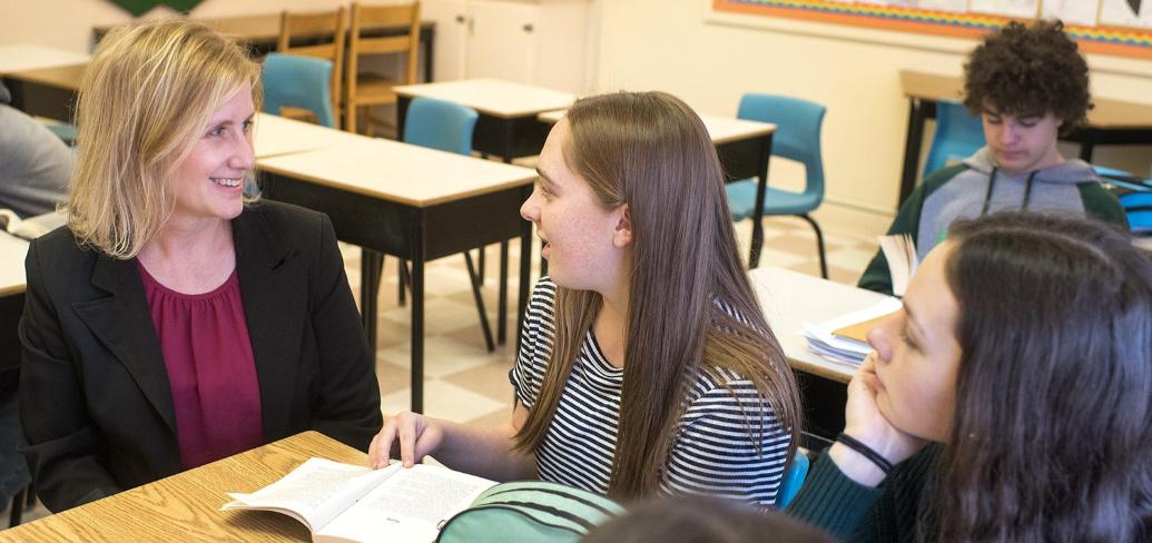 Birchwood teacher Frances Ann Squire sits at a table talking with two students