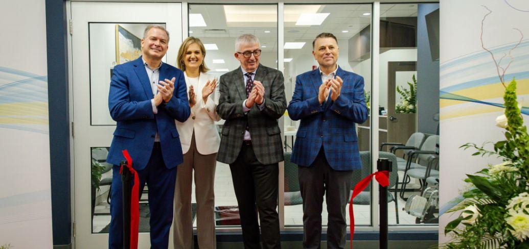 image of four people clapping their hands after a ribbon cutting ceremony