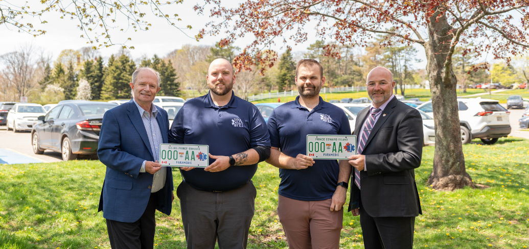 photo of four people, with license plates 