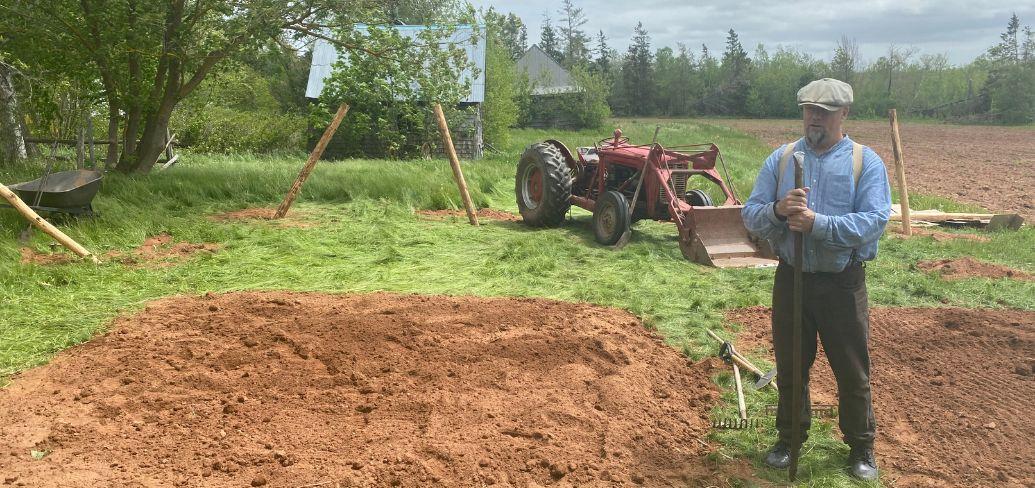 image of a person in a garden beside a field and tractor