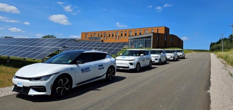 EVs parked in front of solar panels.