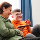 image of an older person and a younger person sitting on a couch and laughing