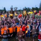 image d'un groupe de personnes avec les mains levées dans un champ