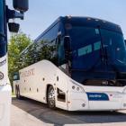 image of three motorcoach buses parked beside each other in a parking lot on a summer day