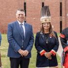 image of four people standing shoulder to shoulder with a brick building in the background