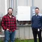 image of four people standing in front of some energy efficiency equipment outside a community rink